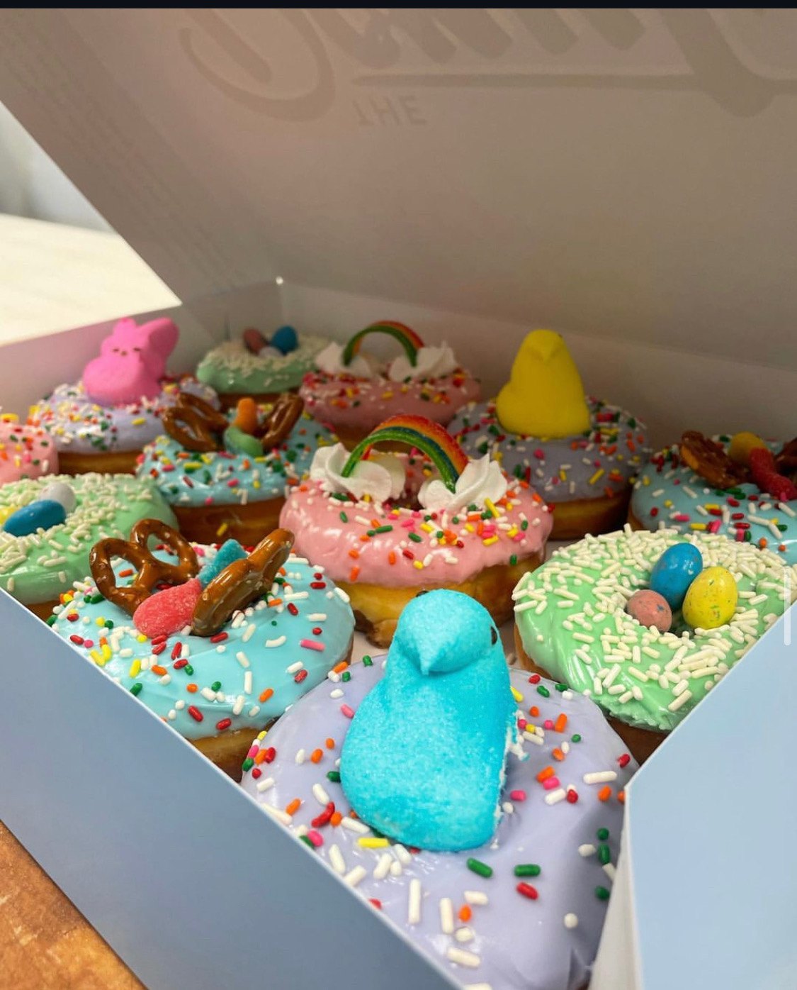 An Easter box of decorated donuts with Peeps and pastel icing