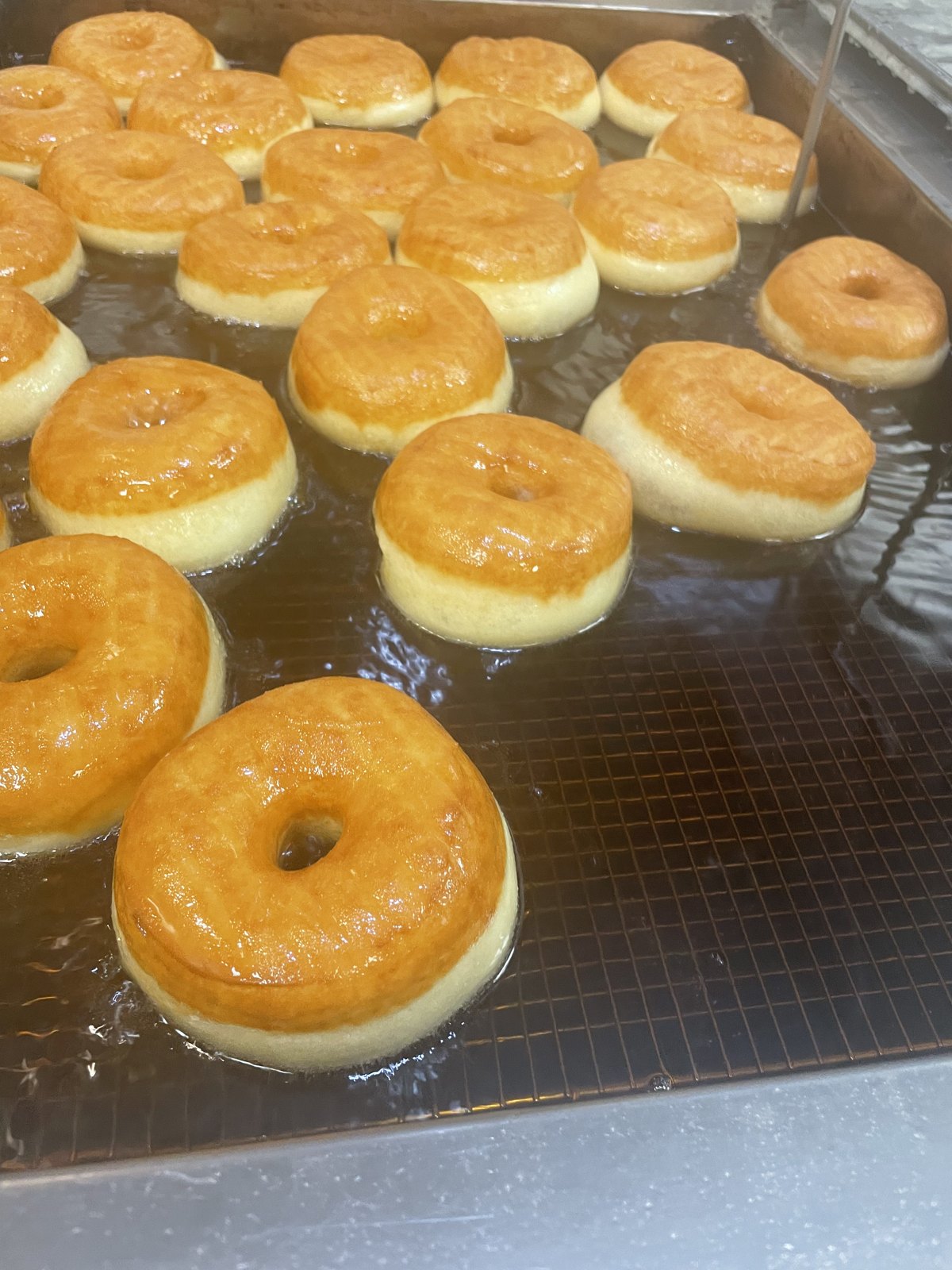 Donuts in the fryer at The Donut Run, early morning